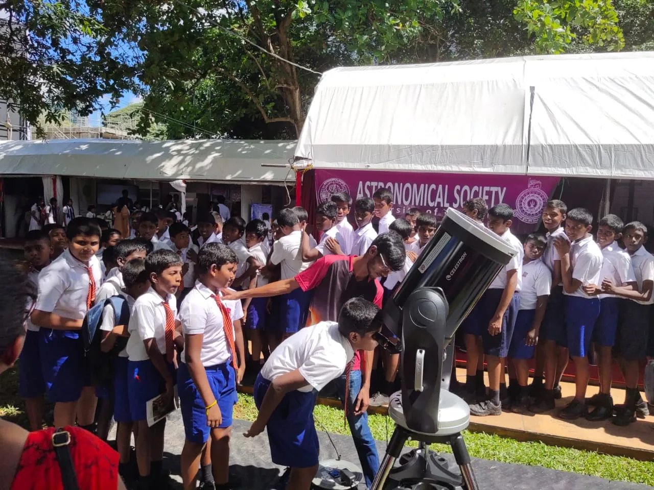 Students gathered around a telescope during a public astronomy programme