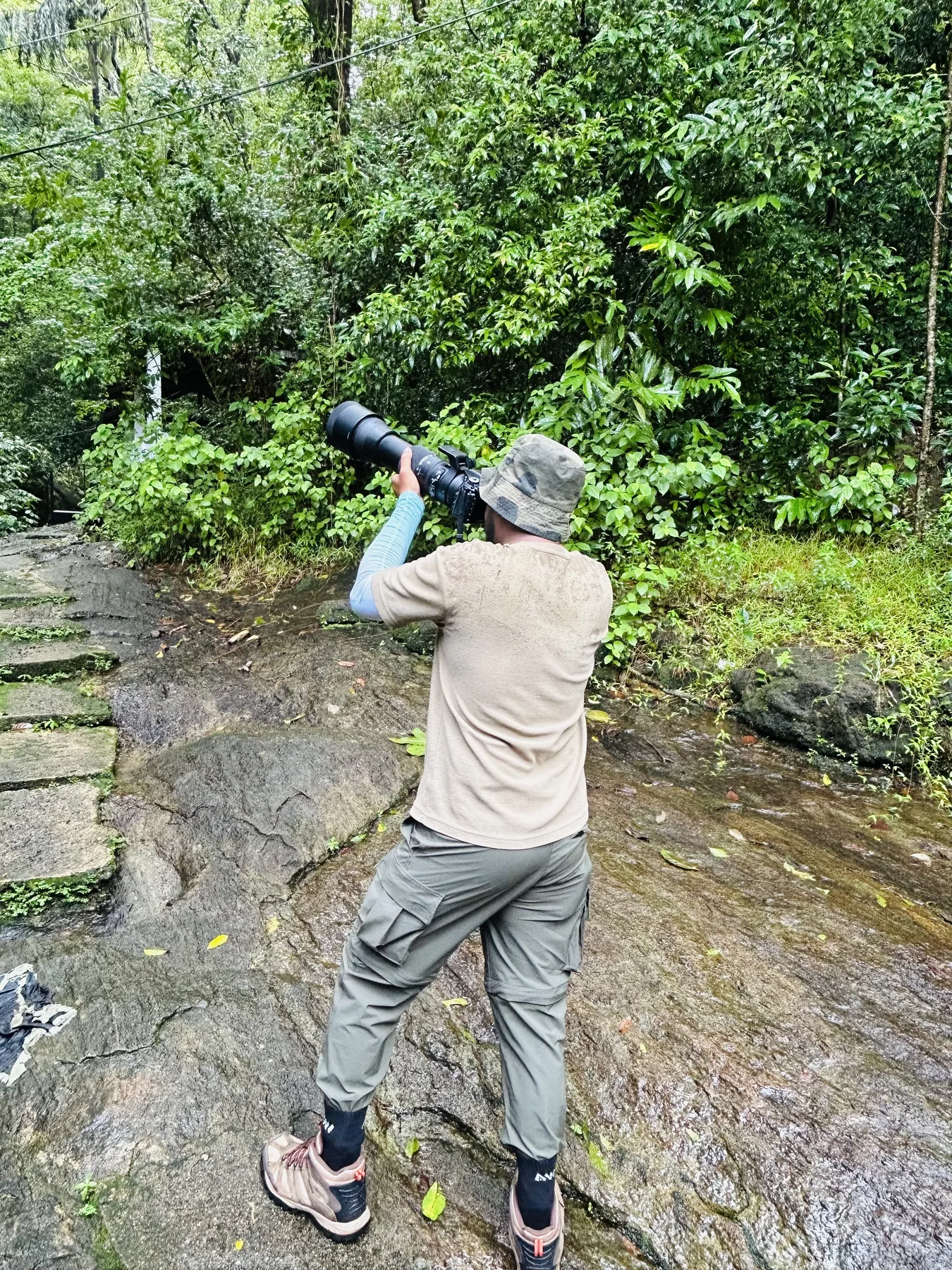 Sahan photographing beside a forest stream