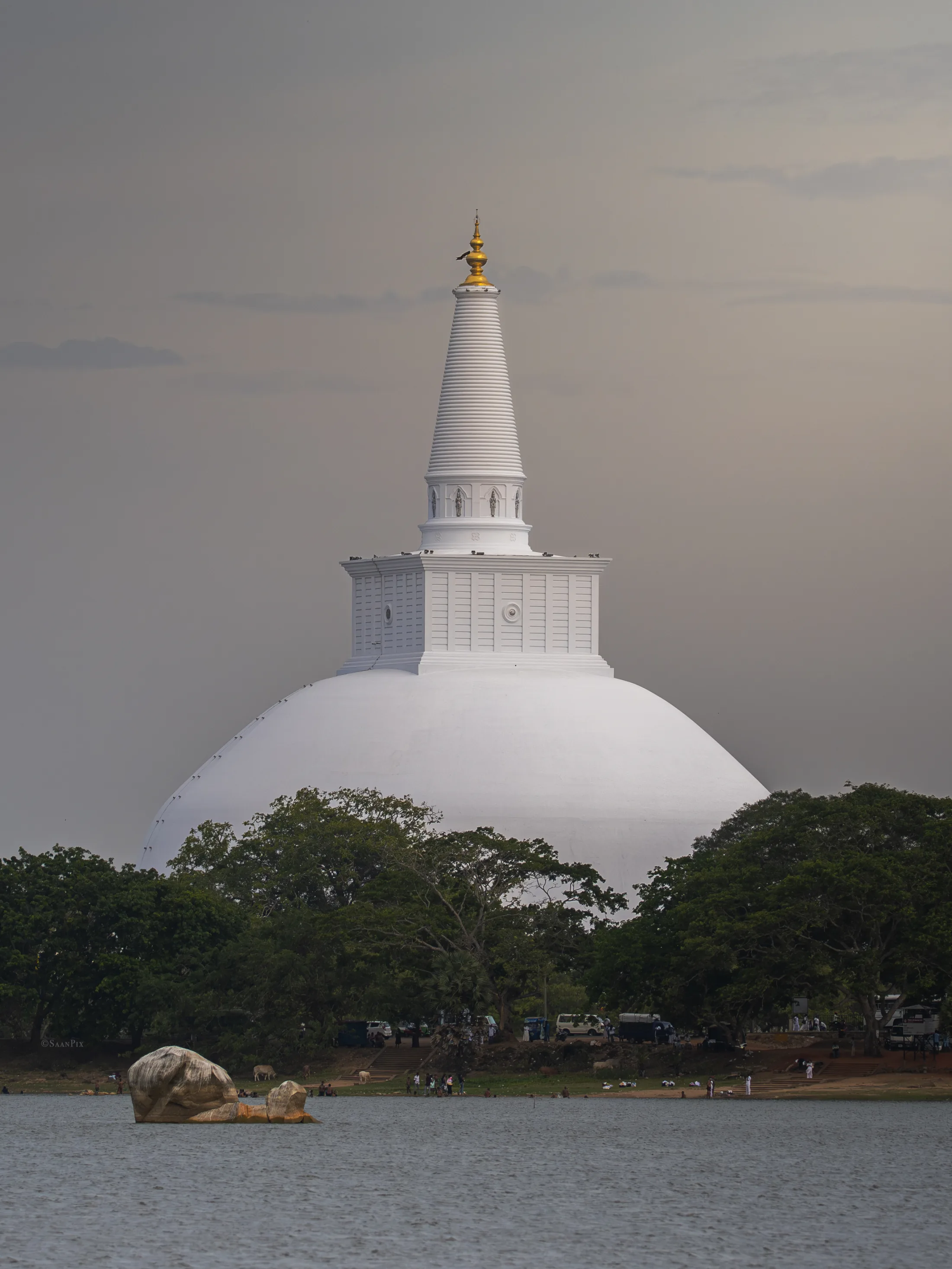 White stupa seen across water and trees