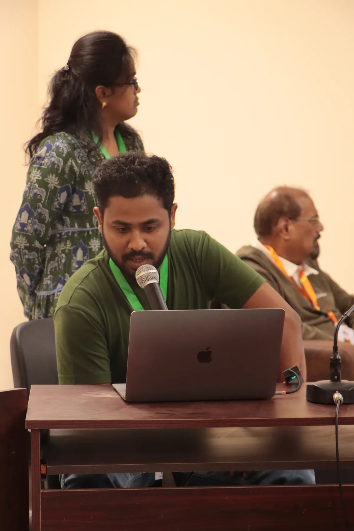 Sahan speaking into a microphone while working at a laptop during COSPAR 2026